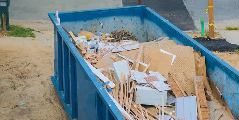 Jobsite dumpster filled with scrap wood and framing lumber from a build