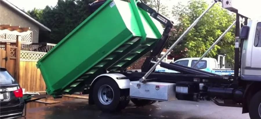 Dumpster packed with tangled scrap metal and appliances at a jobsite