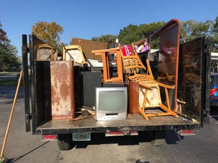 Roll-off dumpster loaded with cleanout and construction debris at a job site (26)