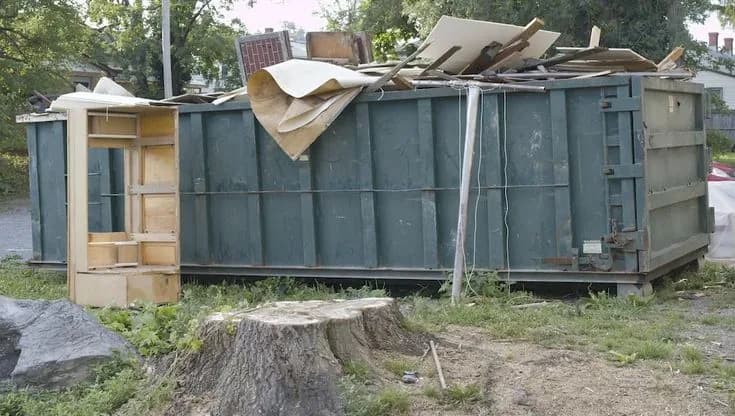 Roll-off dumpster loaded with cleanout and construction debris at a job site (30)