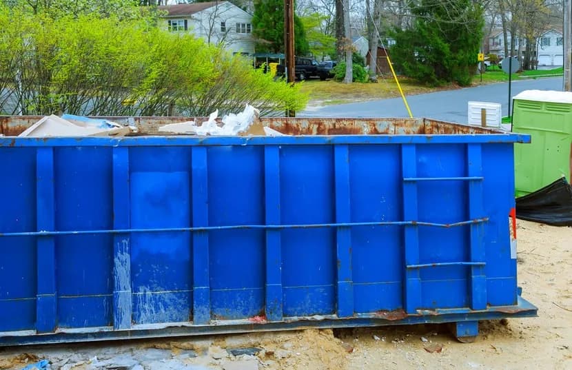 Blue 20 yard roll-off dumpster placed on a residential driveway for a rental