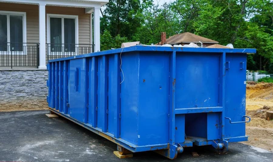 Orange roll-off dumpster delivered to a residential home improvement project